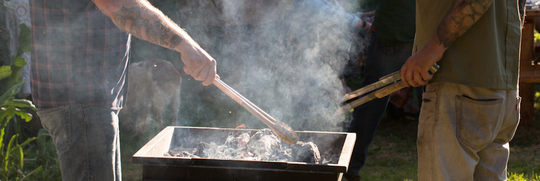 people grilling Olympia Provisions meats on a charcoal grill for Labor Day