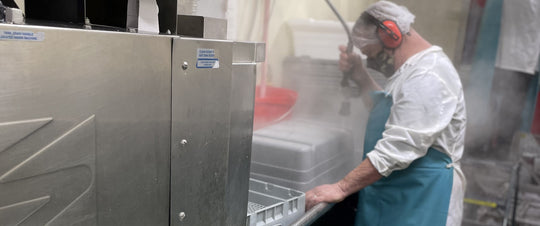 Worker in Apron Washing Dishes