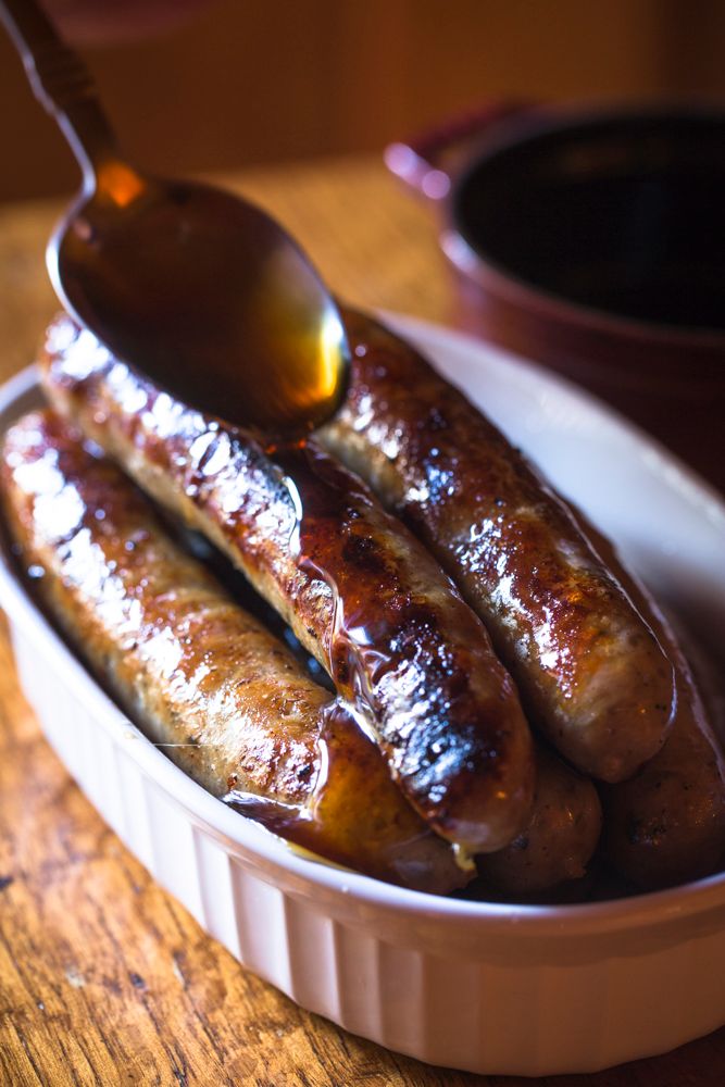 breafast sausages in a dish being glazed with honey