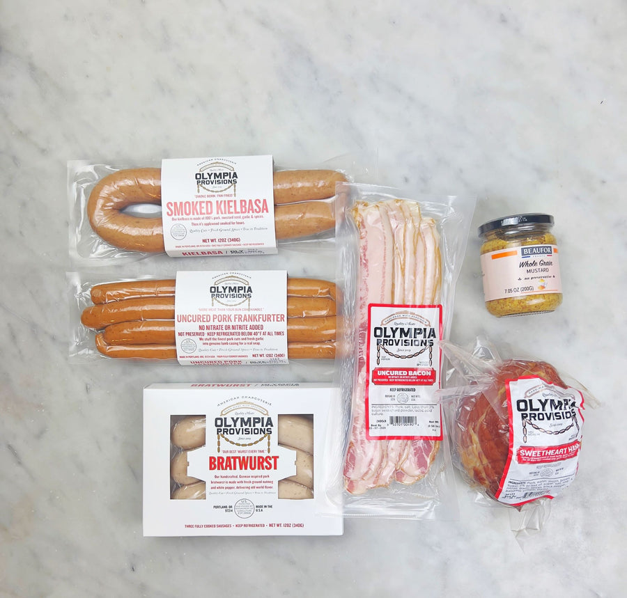 asorted olympia provisions meats including smoked kielbasa, uncured pork frankfurters, bratwurst, a sweetheart ham, and uncured bacon