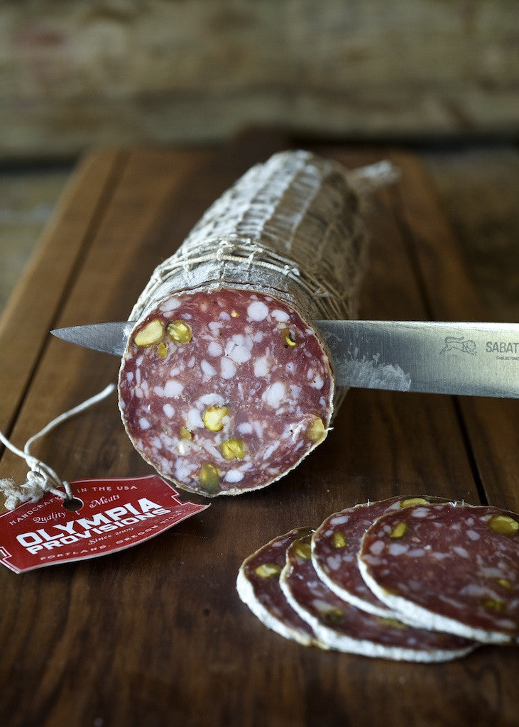 slicing Etna salami on a cutting baord