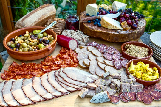 huge charcuterie board featuring Olympia Provisions cured deli meats, sausages and pickles