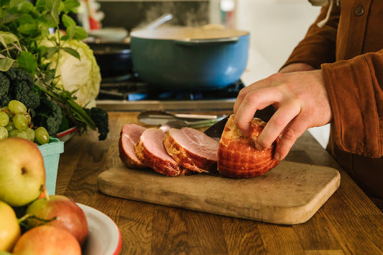 person slicing sweetheart ham for a cabbage and apple recipe