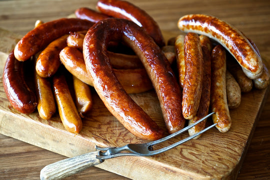 wooden board with several different Olympia Provisions sausages