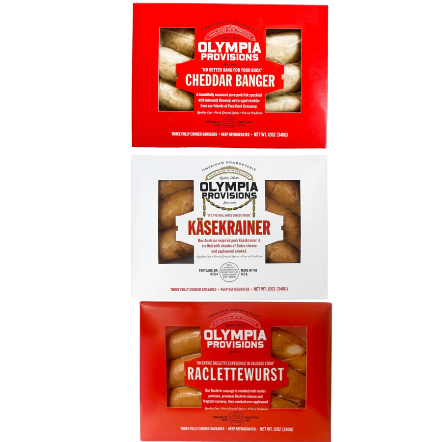 Three packages of Olympia Provisions sausages in red and white boxes on a white background