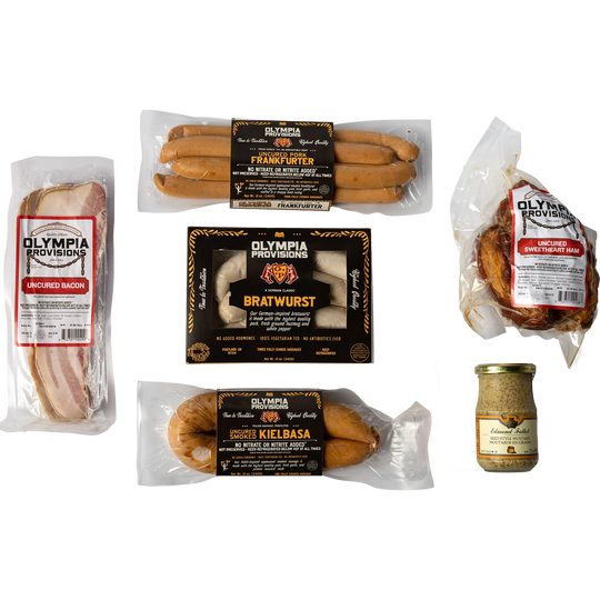 Assorted Olympia Provisions sausages, ham, bacon, mustard on a white background.
