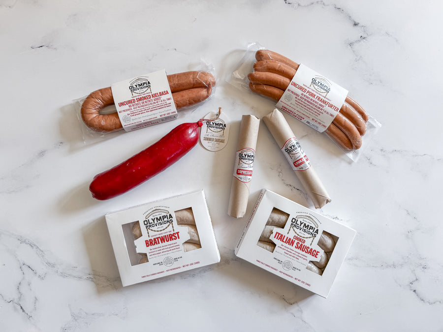 italian sausage, bratwurst, frankfurter, summer sausage, kielbasa and two salamis laid on marble 