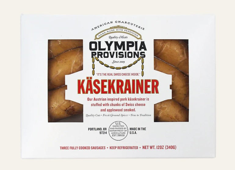 Olympia Provisions Käsekrainer sausage packaging on a beige background