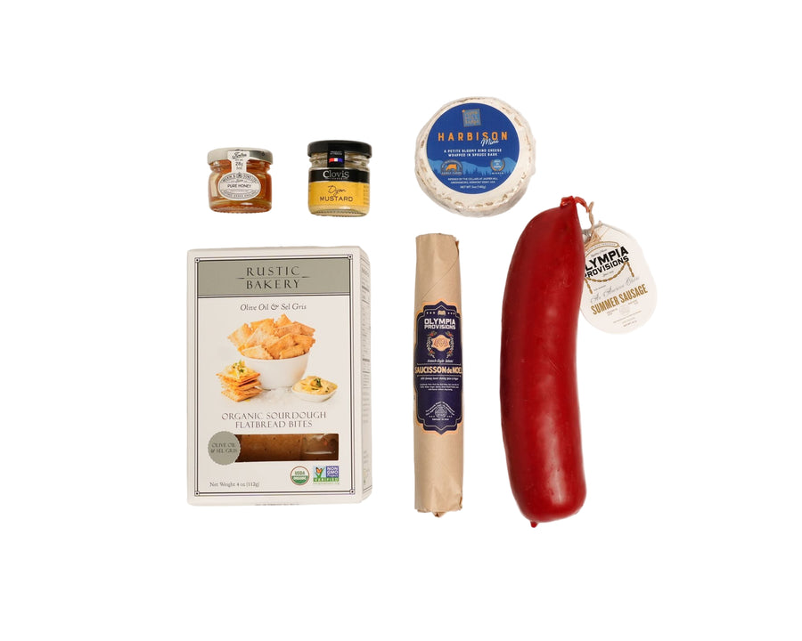 Assorted food items including a package of crackers, dijon, honey, salami, harbison, and summer sausage on white background