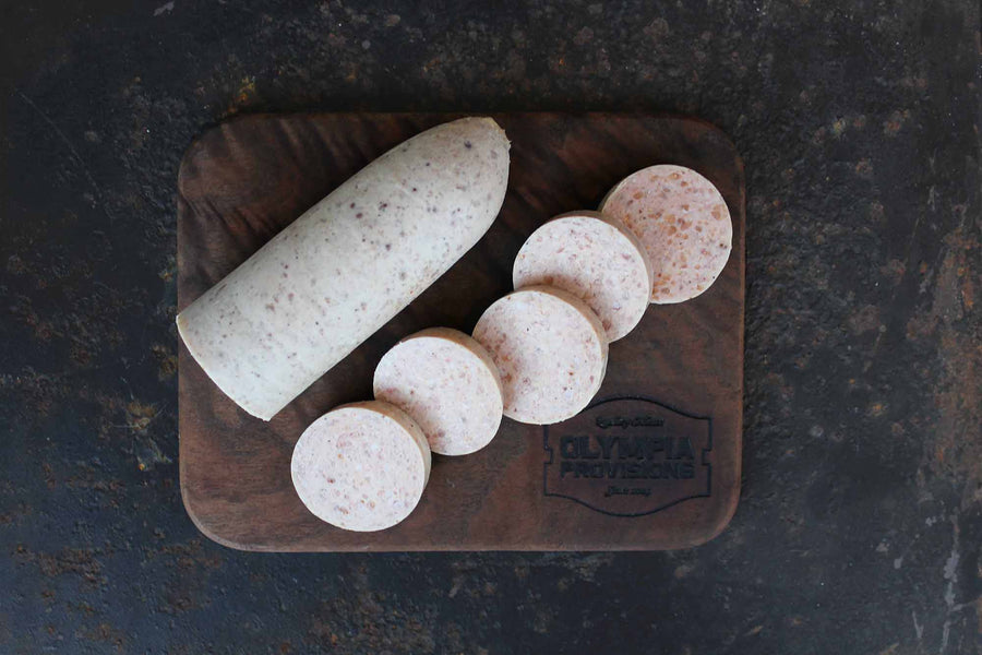 Raw Cotechino sausage, cut on a wooden board