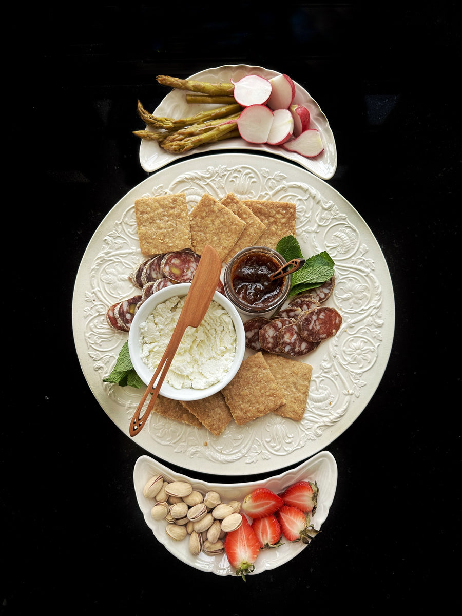 spring charcuterie plates wth salami, cheese, jam, radish, asparagus, strawberries and pistachios and crackers